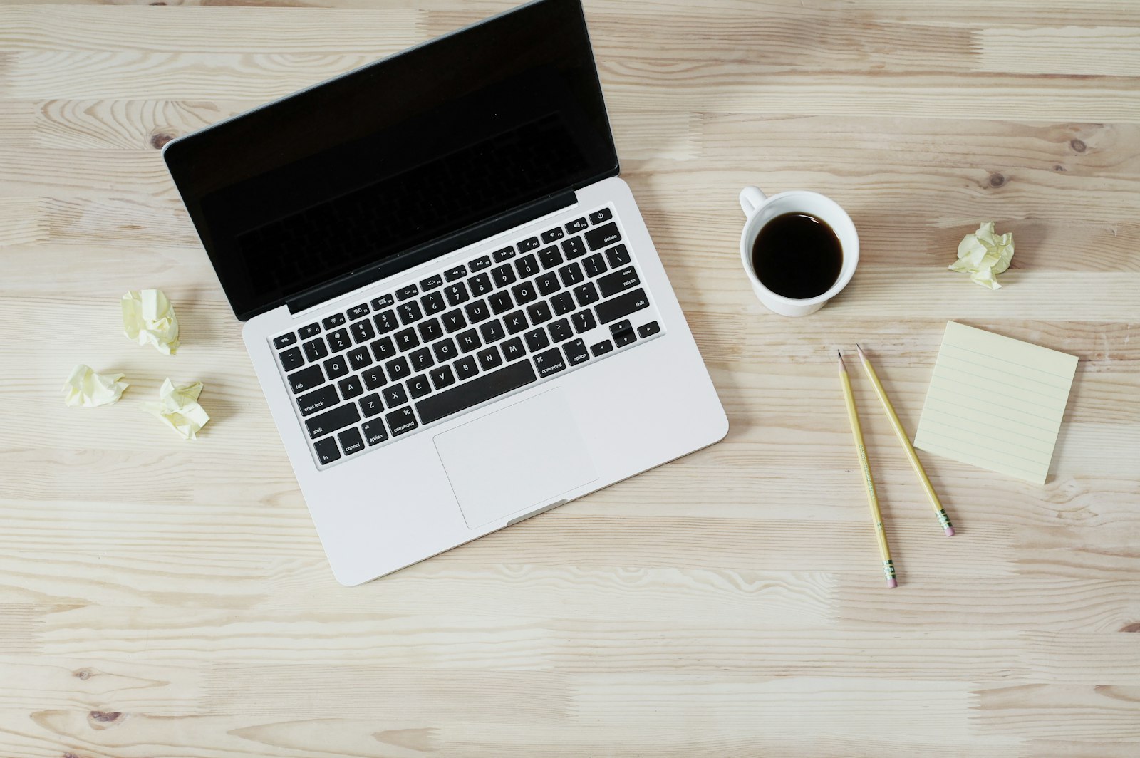 Laptop beside white ceramic mug