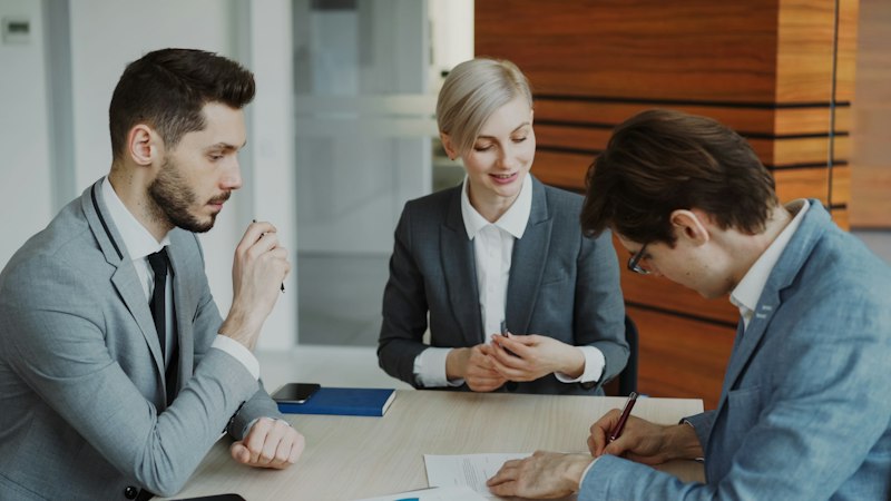 People signing a contract at a table